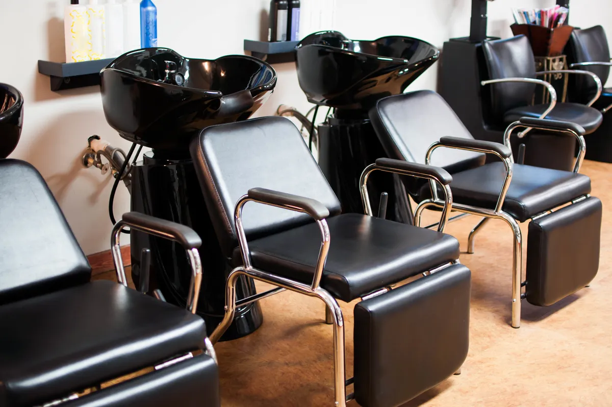 The shampoo lounge inside the salon, with black bowls and styling chairs