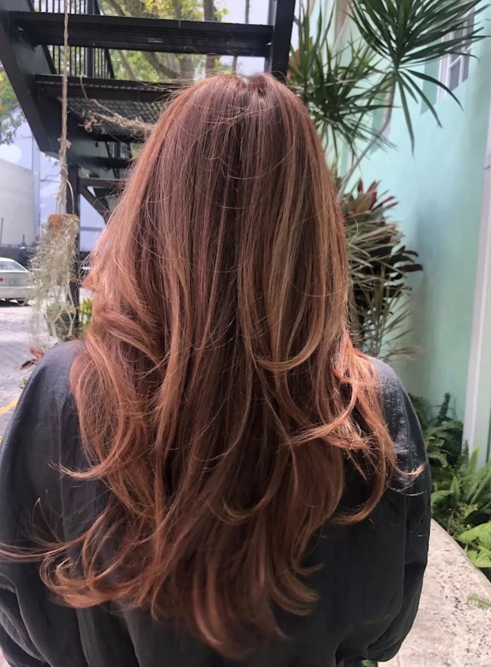 Long auburn hair lengthened and finished in waves