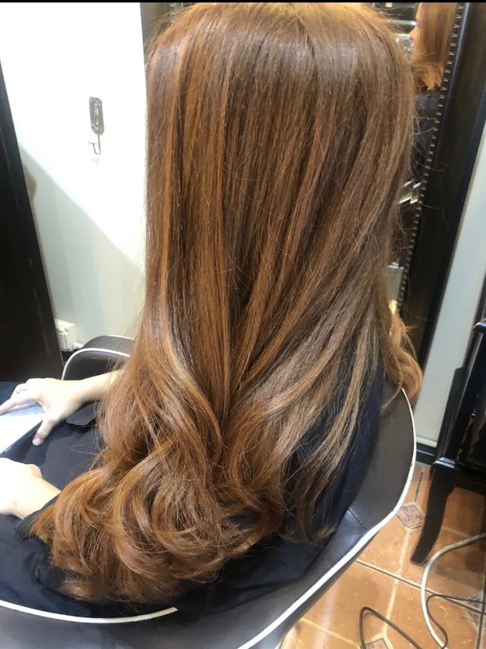 A finished haircut with long, soft layers seen from behind