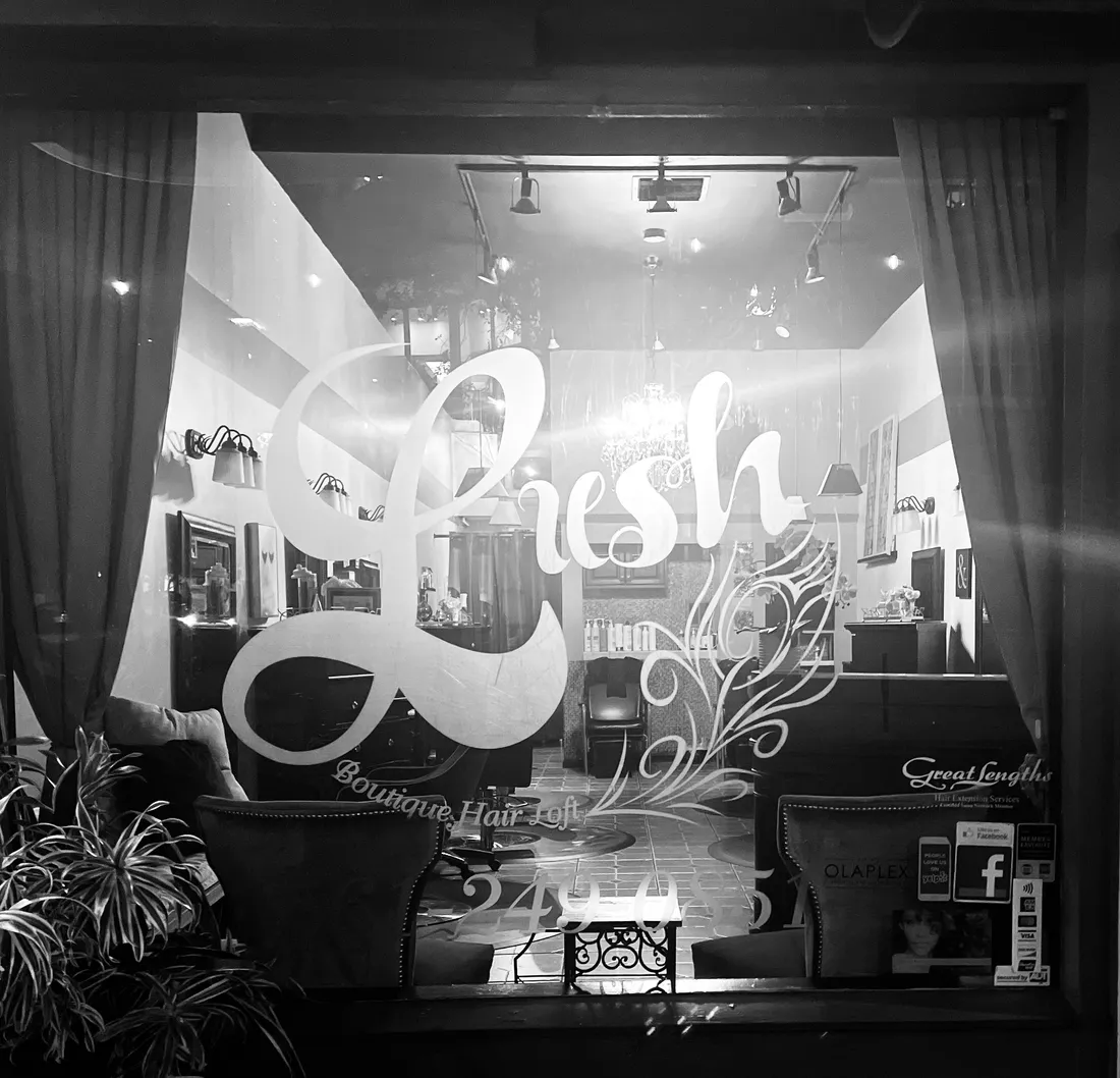 Looking into the salon from the front window, with the aqua Lush sign on the glass